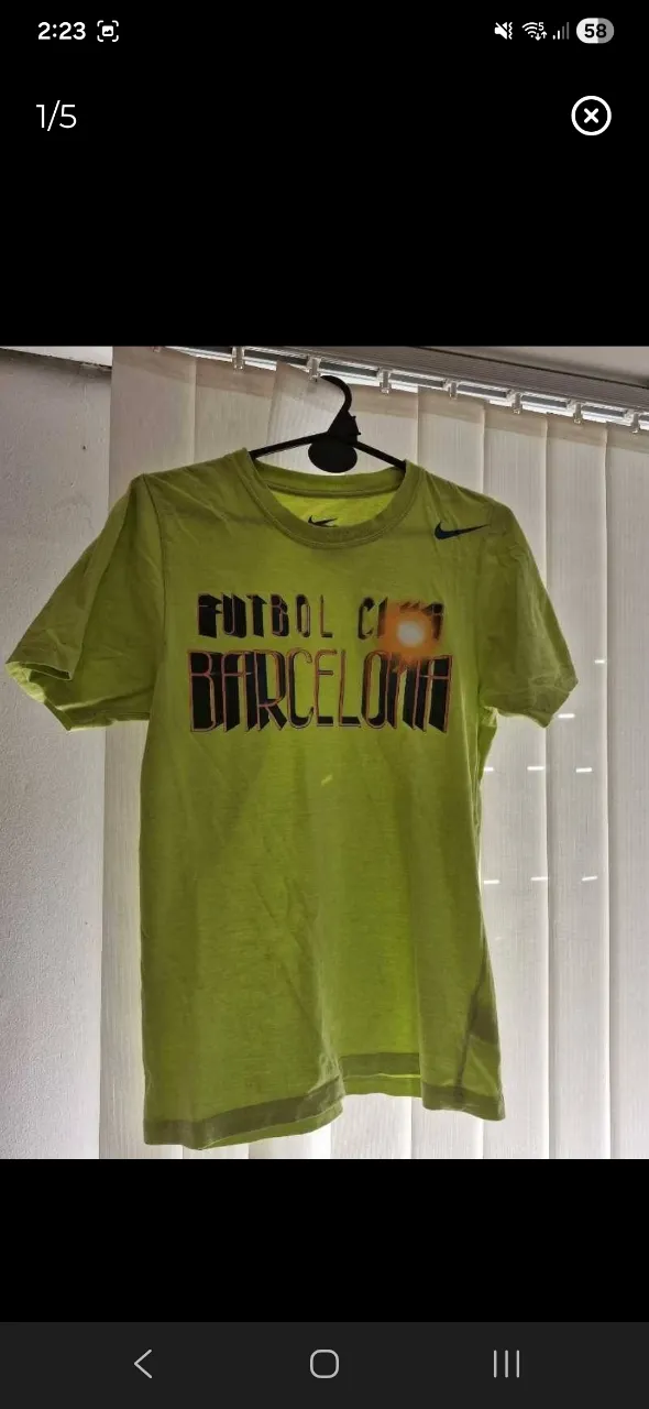 Remera de algodón color verde lima con estampa de "FUTBOL CLUB BARCELONA" en el frente. Logo de Nike y escudo del club en la espalda.