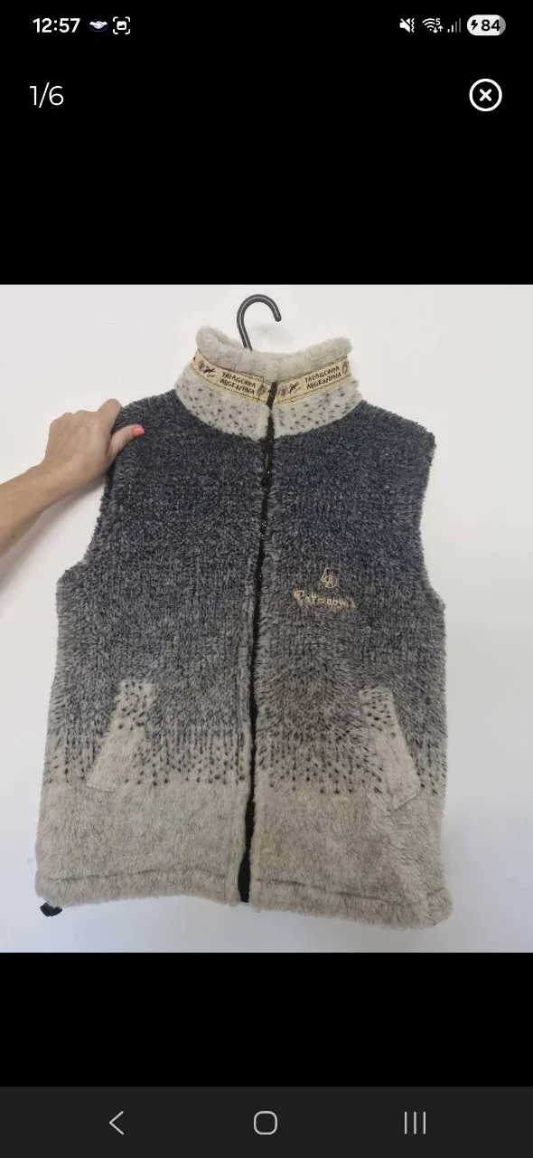 Chaleco de abrigo con cuello alto y cierre al frente. Posee dos bolsillos laterales y un bordado en la espalda.