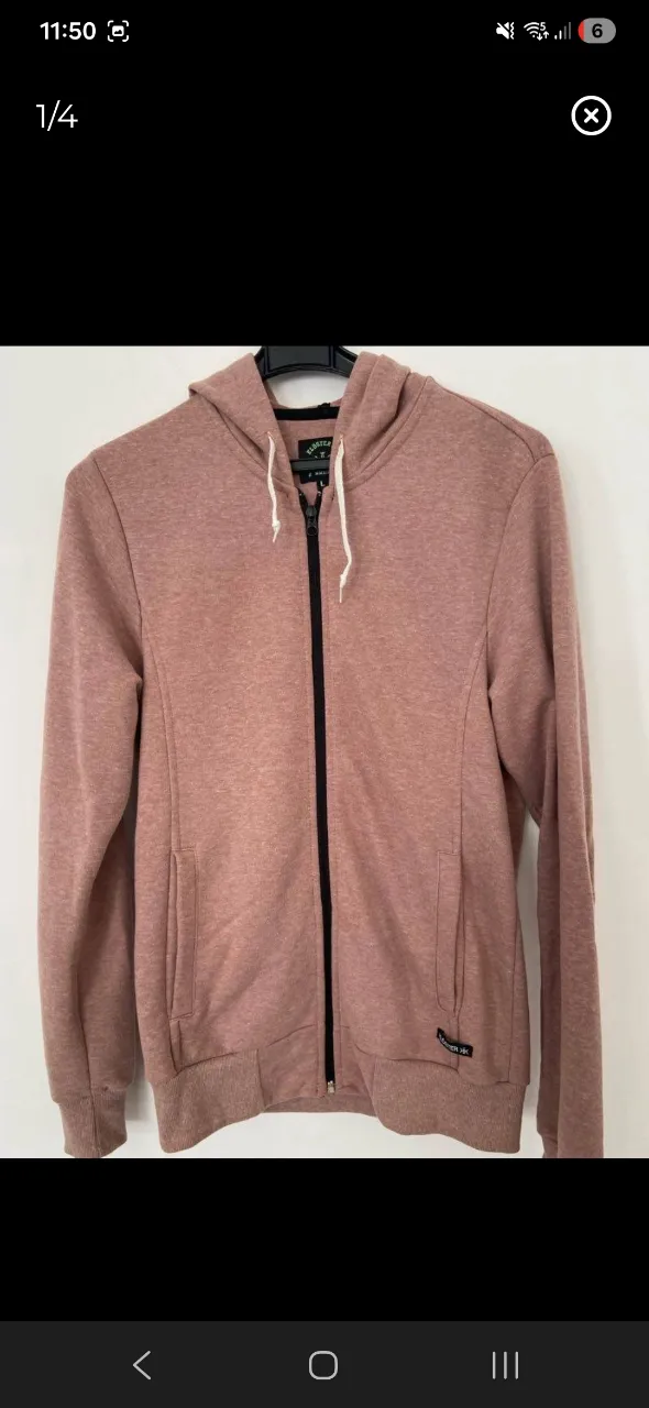 Buzo con capucha y cierre completo. Posee bolsillos frontales y cordones blancos en la capucha.