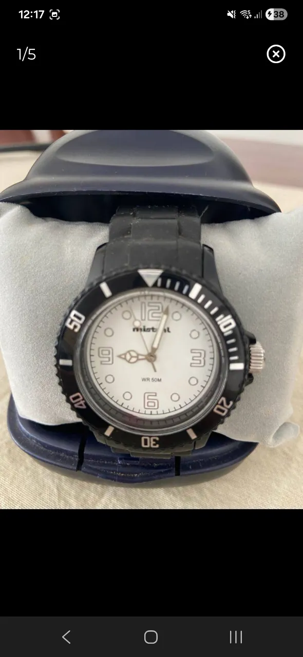 Reloj Mistral con malla de caucho negra y caja negra. Esfera blanca con números arábigos y agujas negras. Resistente al agua 5 ATM.