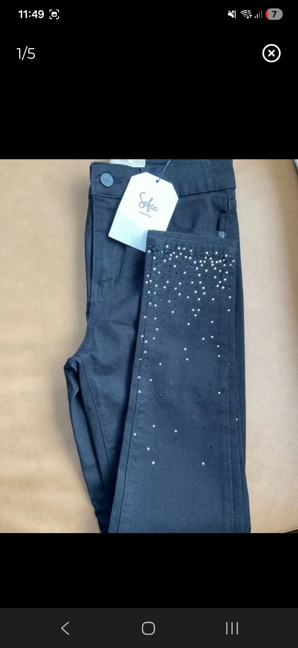 Jean negro con detalles de strass en la parte inferior de las piernas.