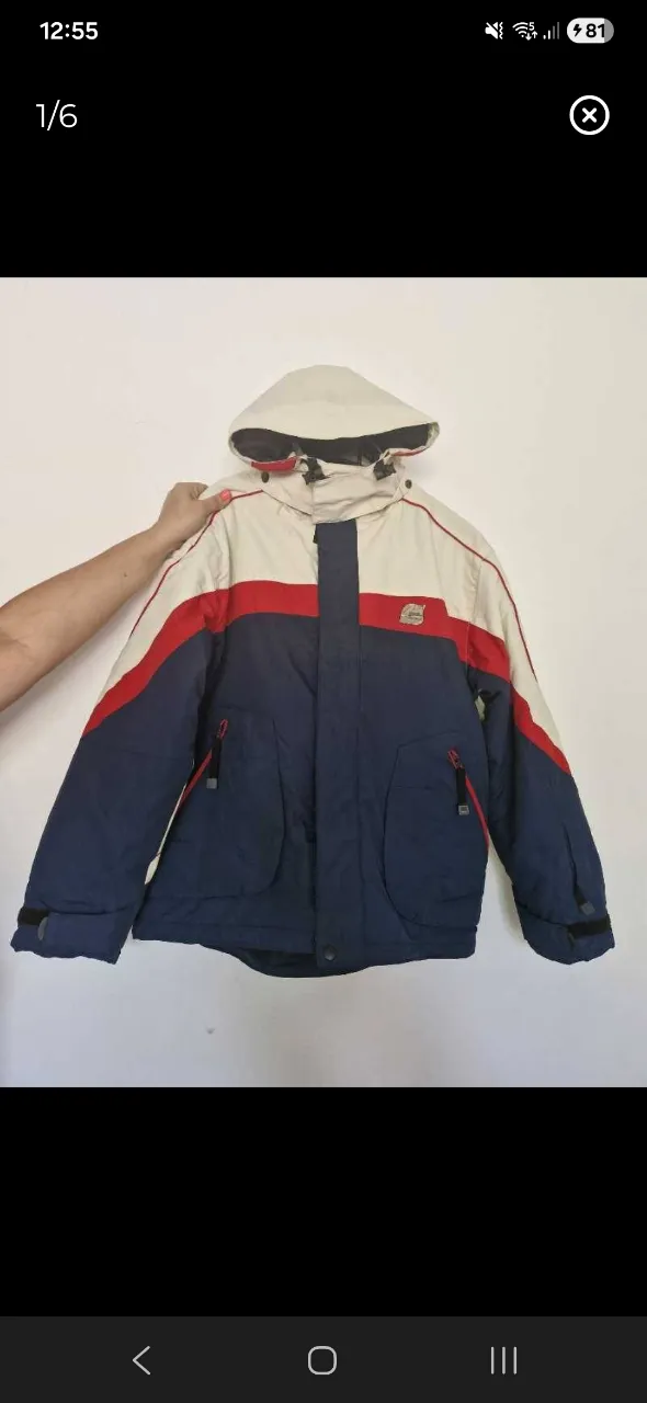 Campera de abrigo con capucha, cierre central y bolsillos frontales con cierre. Diseño tricolor en frente y espalda con detalles en rojo.