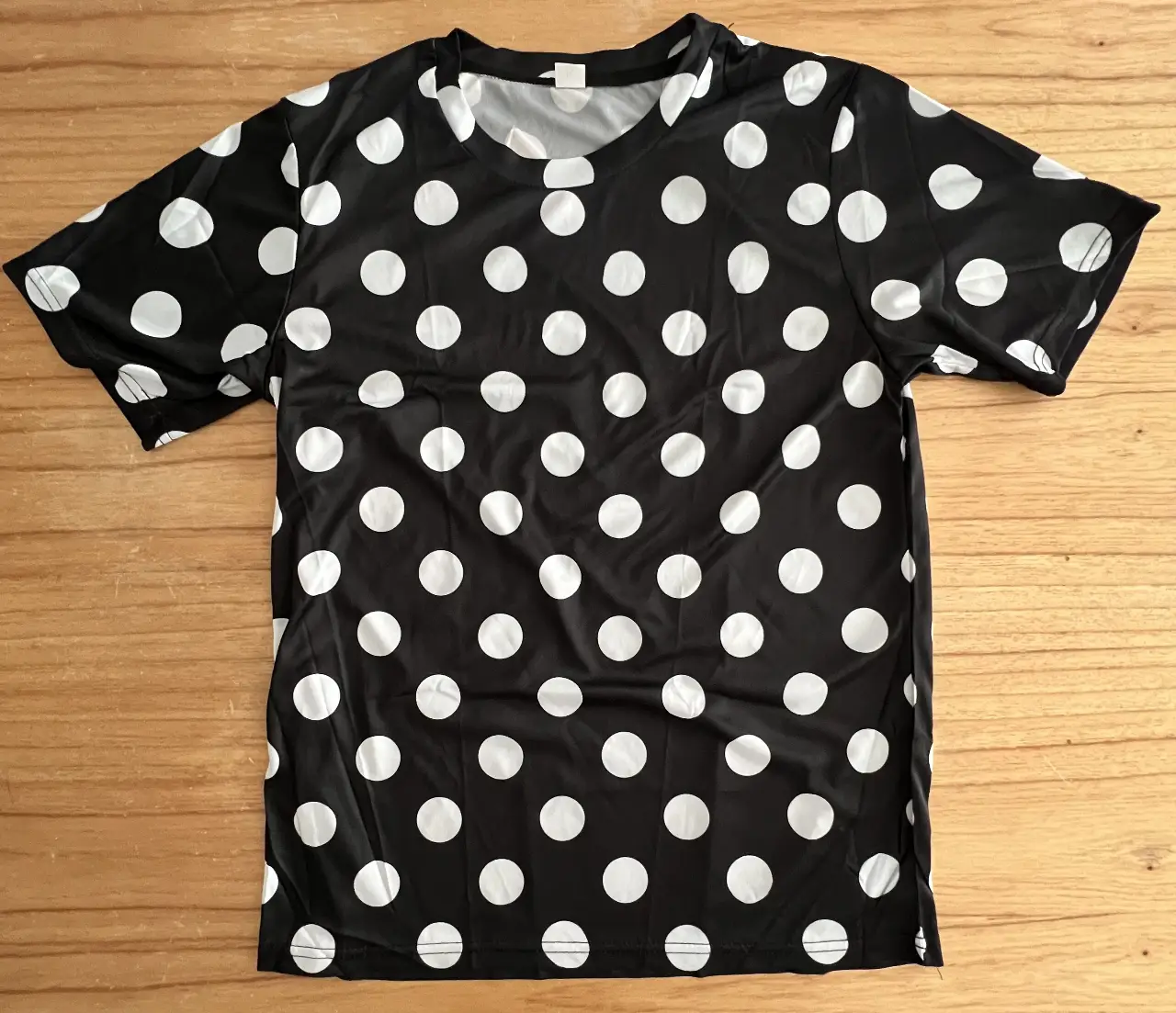 Remera de manga corta con estampado de lunares grandes. Disponible en blanco con lunares negros, azul marino con lunares blancos y negro con lunares blancos. Ideal para un look casual y moderno.