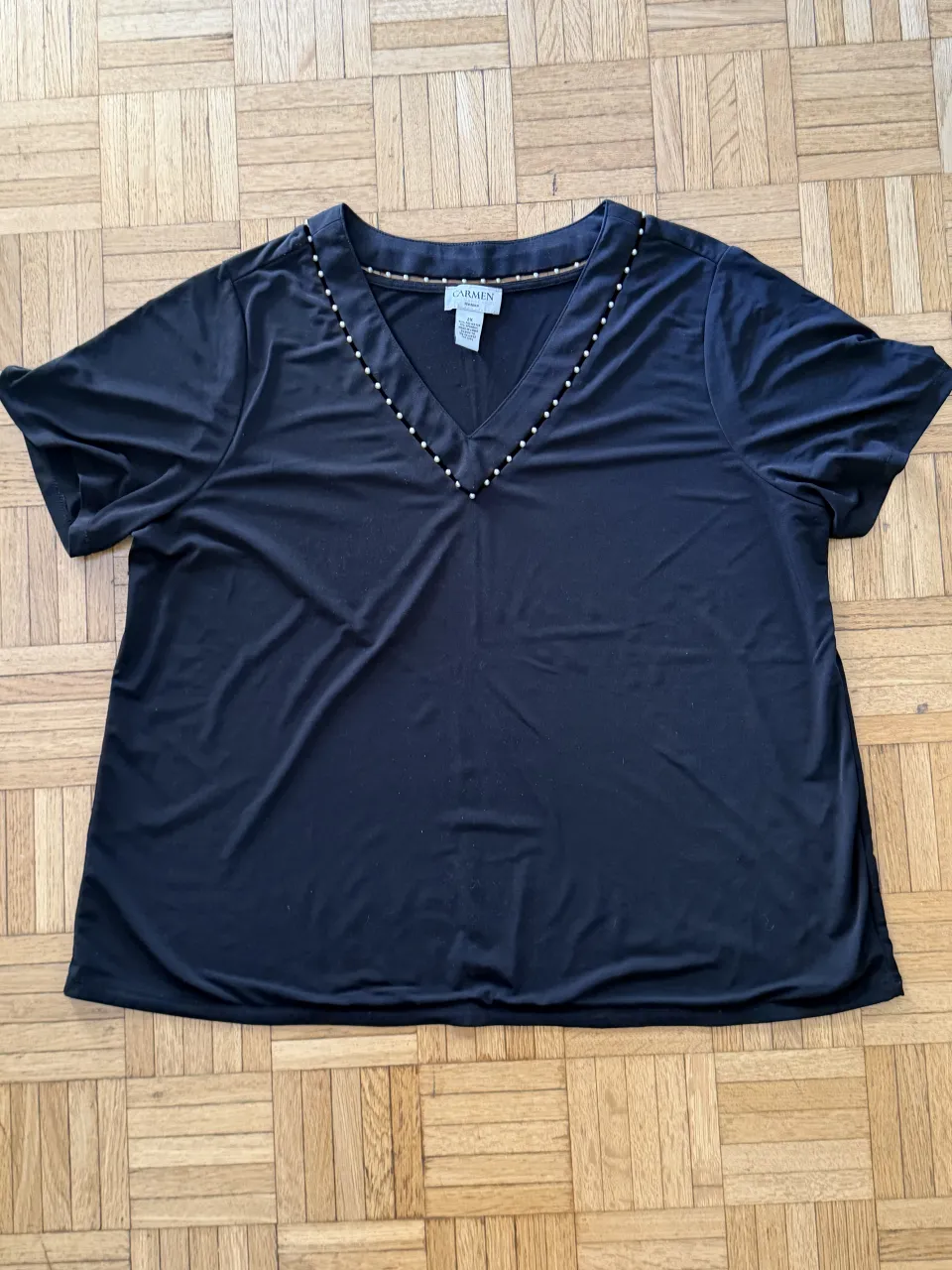 Remera negra de manga corta con escote en V adornado con pequeñas perlas. Excelente calidad, doble tela. Marca CARMEN.