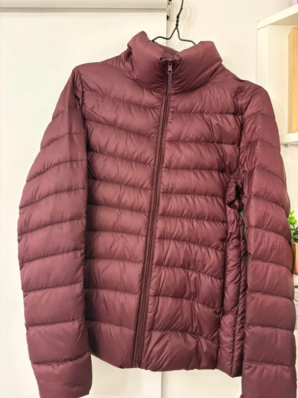 Campera de pluma Uniqlo color borravino, talle XS. Ideal para el invierno, abrigada y liviana. Cierre frontal y cuello alto.