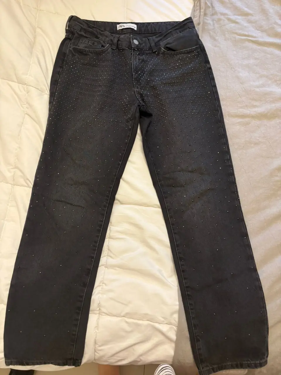 Jeans negros de mujer de la marca Zara, con detalles de strass. Talle 6, tiro alto y corte recto. Ideal para un look casual con un toque de brillo.