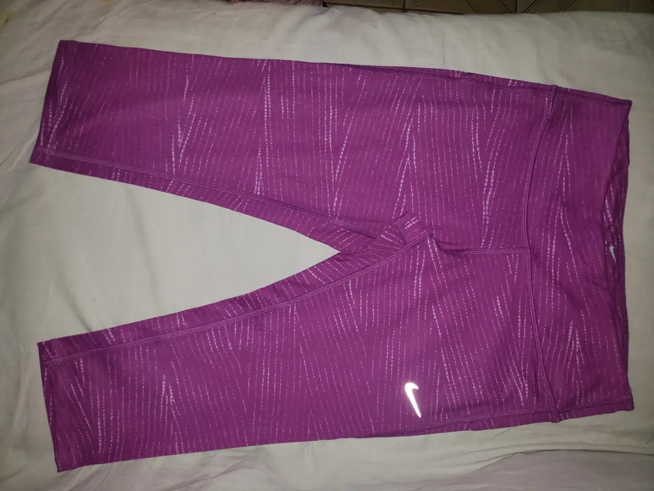 Calzas deportivas Nike Dri-Fit color violeta con diseño. Talle S. Con detalles reflectantes y bolsillo con cierre.