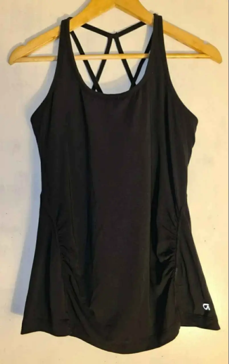 Musculosa GAPFIT breathe deportiva negra con espalda cruzada y detalles fruncidos. Ideal para entrenamientos. contiene sostén interno. 