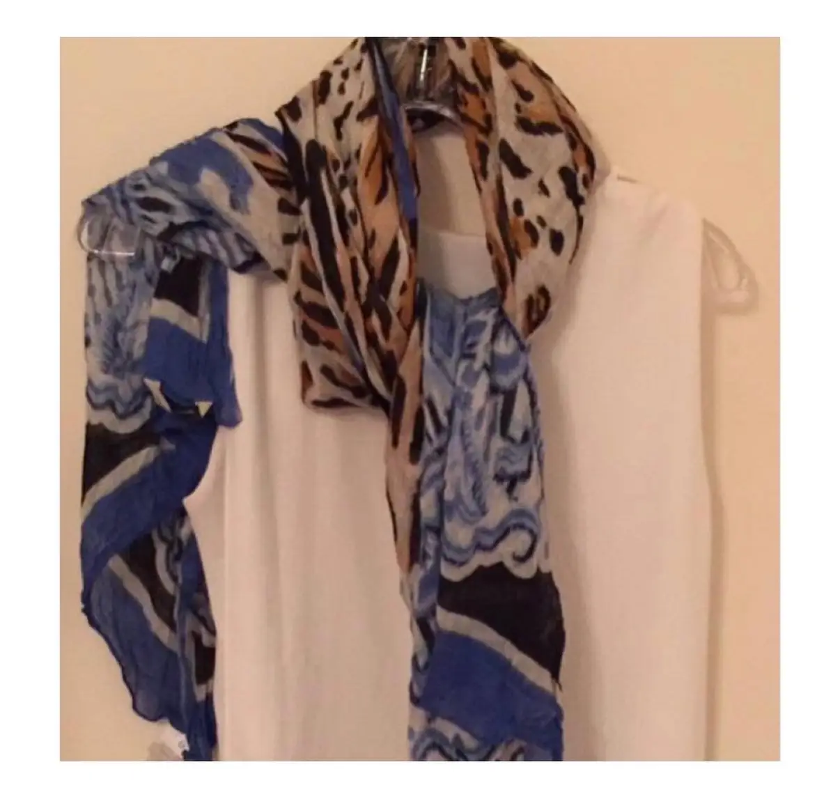 Pañuelo estampado con diseño animal print y detalles florales en tonos azules y beige. Ideal para complementar cualquier look.