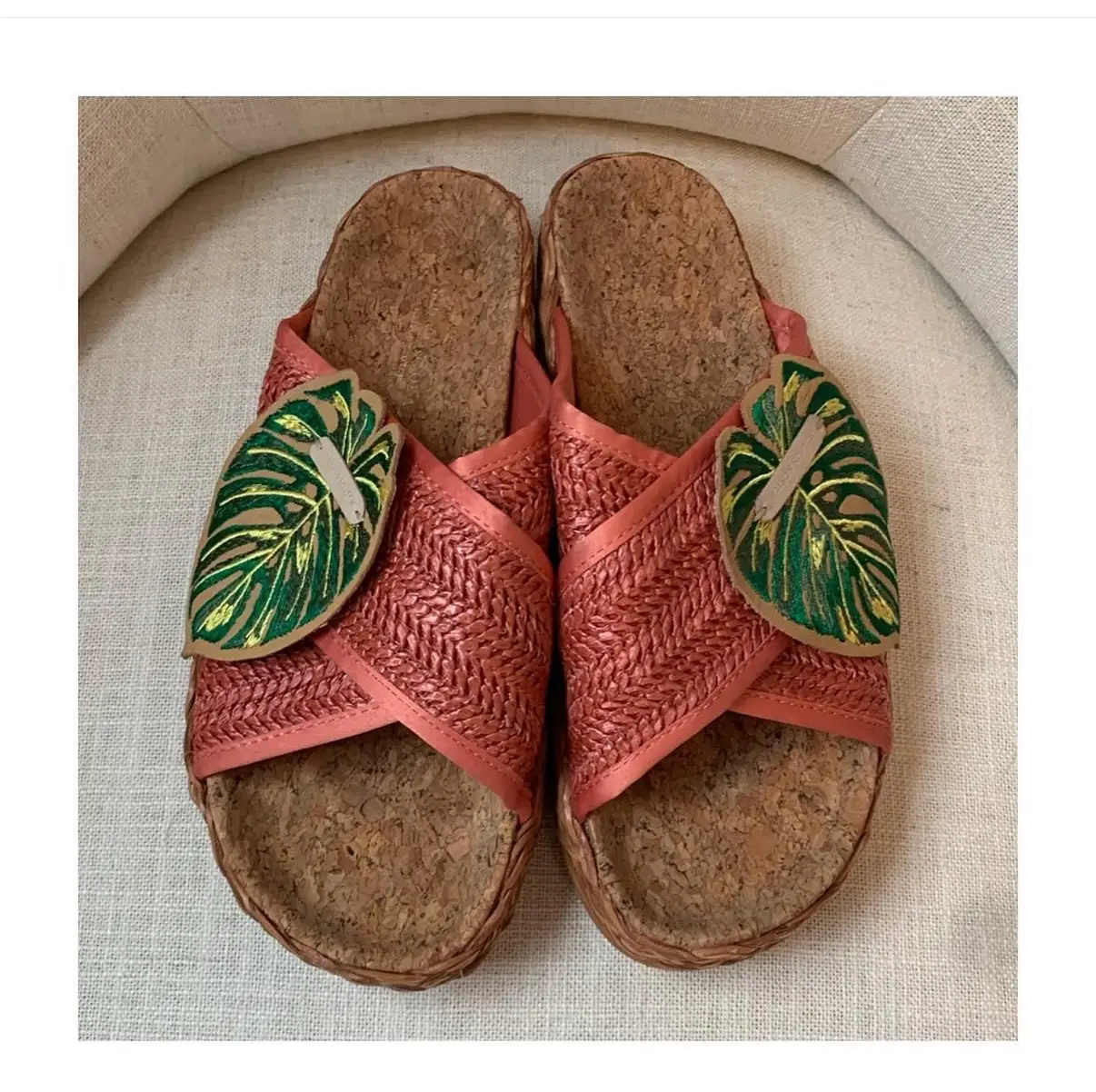 Sandalias de mujer estilo artesanal, con capellada de rafia color coral y detalles de hojas bordadas. Suela de corcho y base de goma con estampado. Talle 40.