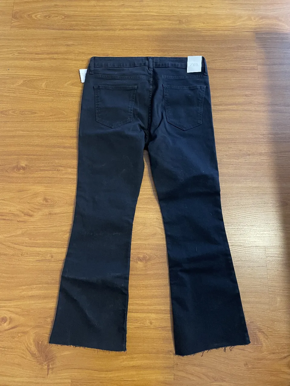 Jeans negro de corte recto con terminación desflecada. Talle 48, de la marca Zara.