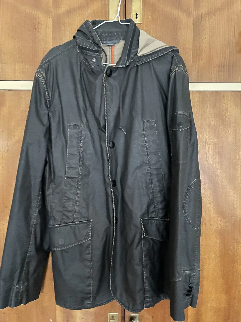 Impermeable  de hombre Armani Exchange negra con capucha. Ideal para lluvia y climas frescos. Posee bolsillos y cierre con botones.