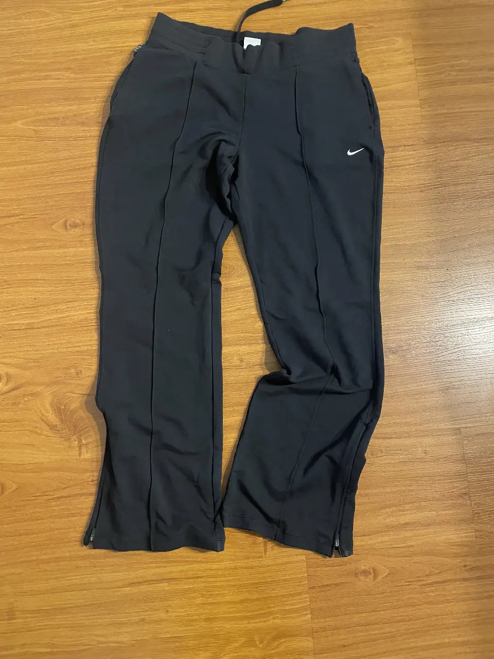 Pantalón deportivo negro de hombre Nike Dri-Fit, con corte recto y detalles de costura. Cuenta con el logo de la marca en blanco y cierre en los tobillos. Talle L.