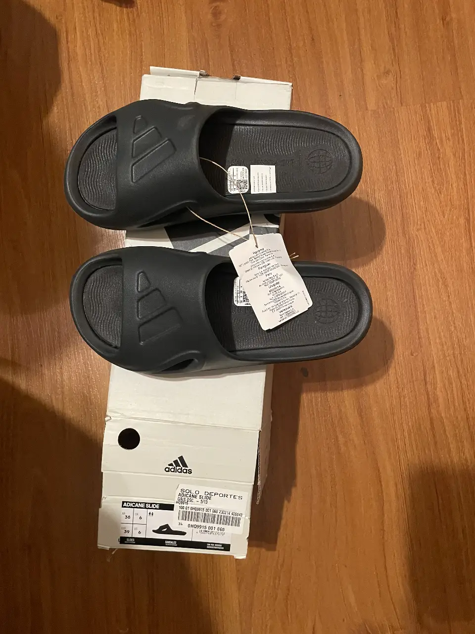 Ojotas Adidas Adicane Slide negras, ideales para el verano. Cómodas y con el logo de la marca.
