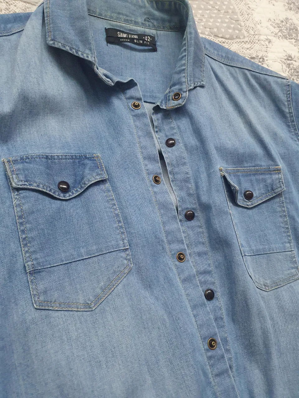 Camisa de jean azul claro, con dos bolsillos delanteros y botones. Corte slim fit, ideal para un look casual y moderno. Talle 42. elastisada.