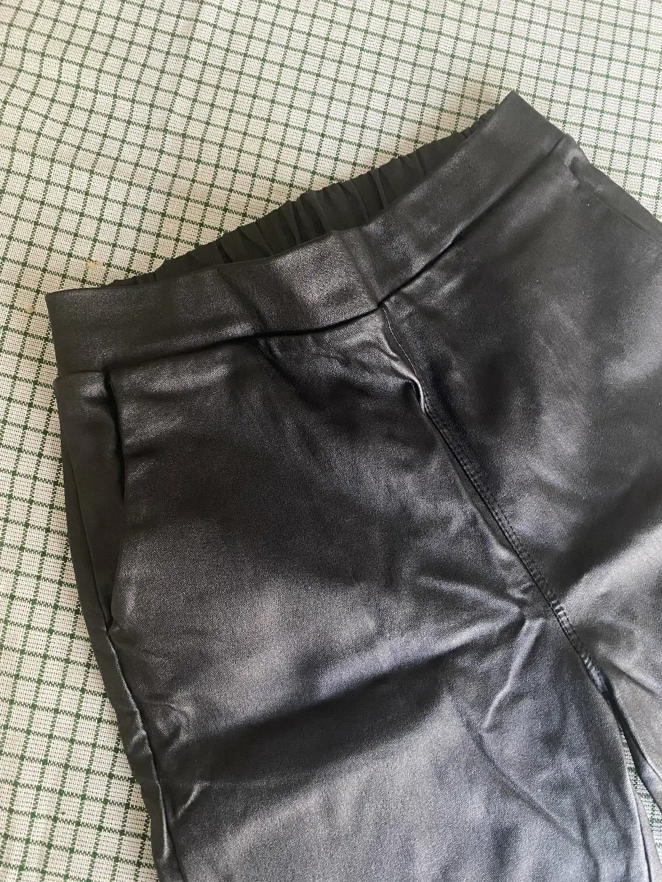 Pantalón chupin cuero sintético elastizado negro, con cintura elastizada y bolsillos laterales. Talle S.