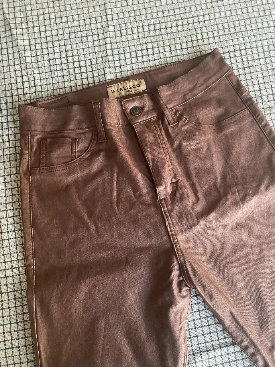 Pantalón de cuerina elastizada de mujer color marrón. Tiro medio, con bolsillos delanteros y traseros. Ideal para un look elegante y sofisticado.