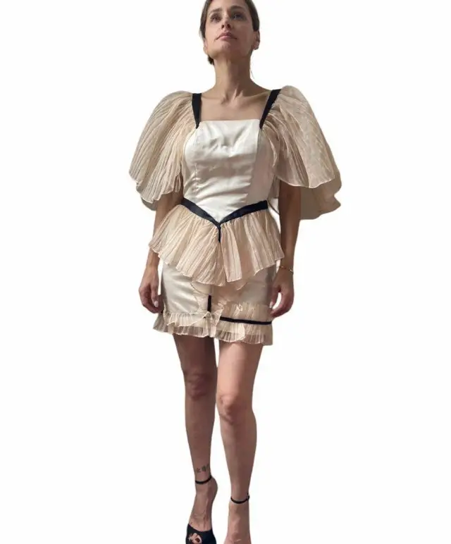 Vestido mini de fiesta con detalles de volados y mangas abullonadas. Diseño elegante y sofisticado, ideal para eventos especiales. Confeccionado con materiales de alta calidad.