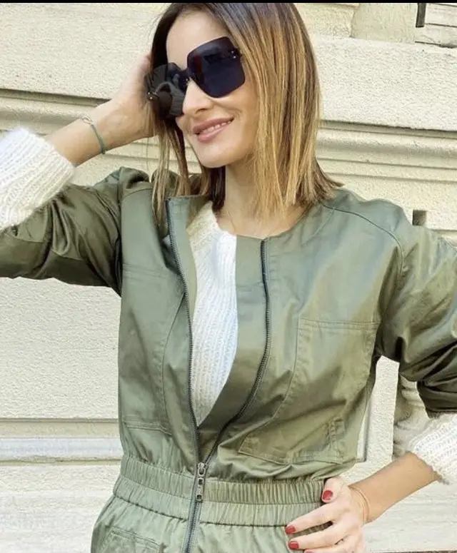 Mono largo de color verde militar, con cierre frontal y cintura elastizada. Bolsillos delanteros y detalles de diseño en las mangas. Ideal para un look casual y moderno.