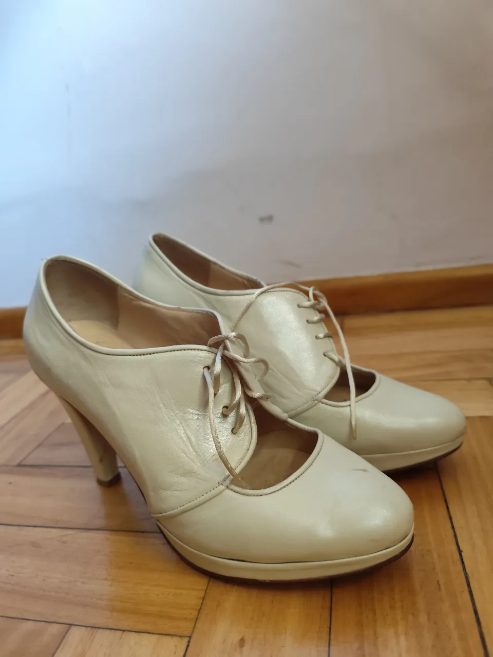 Zapatos de taco color crema con cordones y plataforma. Un diseño elegante y retro, perfecto para darle un toque chic a tu outfit.