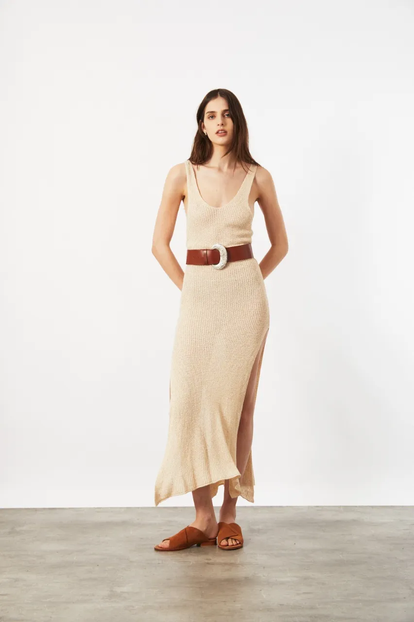 Vestido largo de tejido de punto color crudo, con breteles anchos y tajos profundos a los lados. Ideal para un look canchero y fresco.