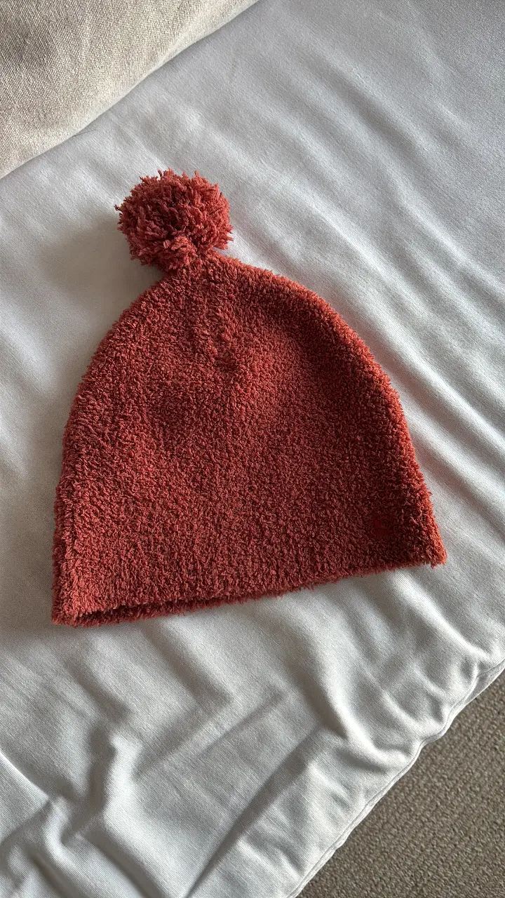 Gorro tejido de color marrón, con pompón en la parte superior. Ideal para el invierno, abrigado y cómodo.