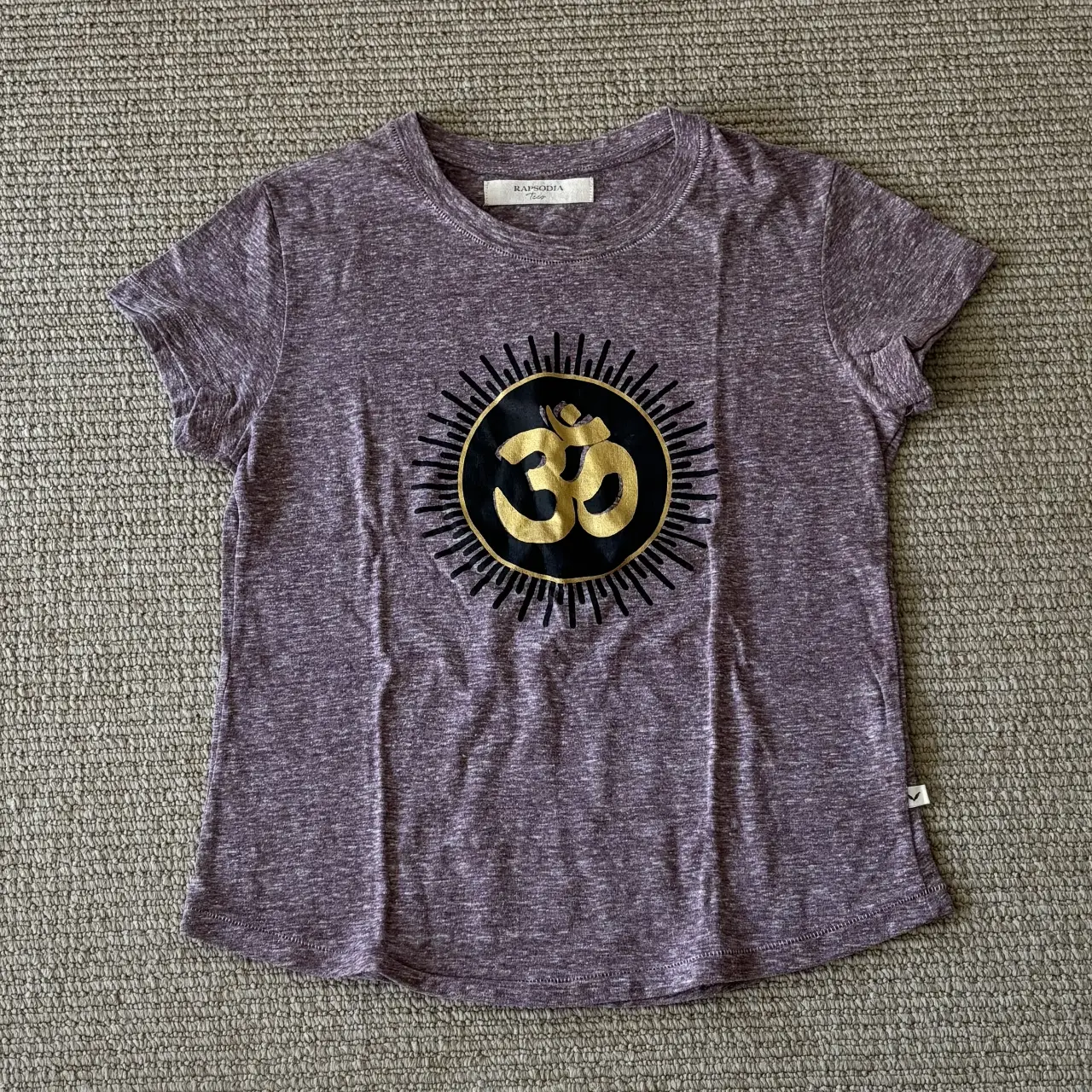 Remera de mujer de color violeta con estampado de símbolo Om en dorado y negro. Marca Rapsodia. Talle XS.