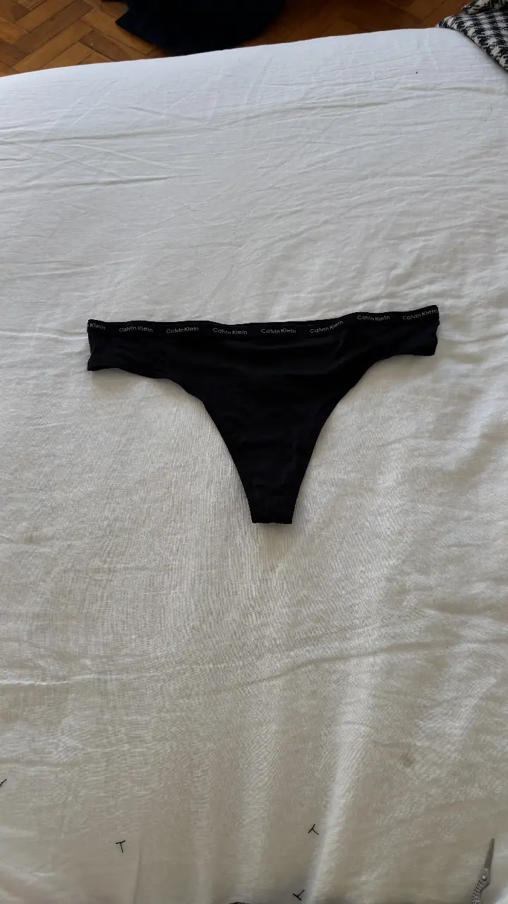 Bombacha Calvin Klein negra de mujer, estilo tanga, con el logo de la marca en la cintura. Ideal para uso diario.