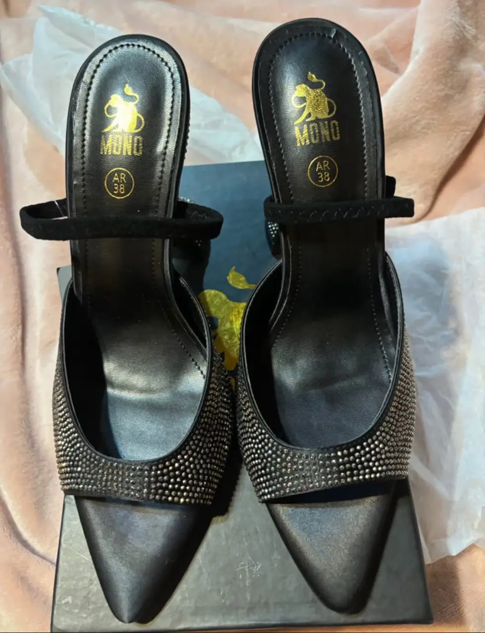 Sandalias de taco alto negras con detalles de strass. Tienen un diseño elegante y sofisticado, ideales para eventos especiales.