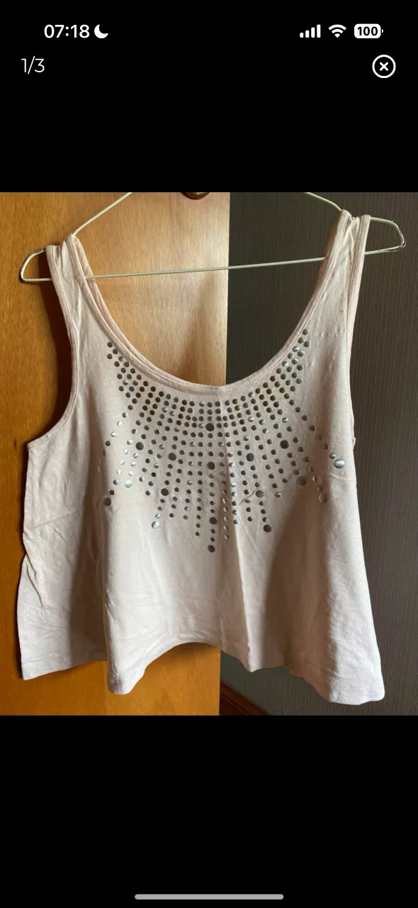 musculosa de mujer, color rosa, con detalles de tachas plateadas en el frente. Marca WANAMA. Ideal para un look casual y moderno.