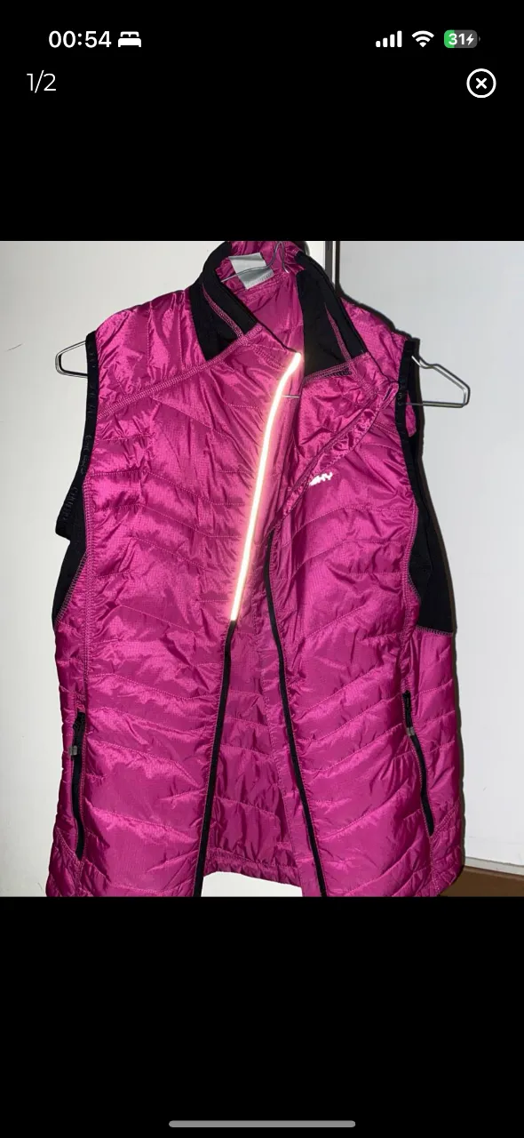 Chaleco acolchado para mujer, color fucsia con detalles en negro. Ideal para actividades al aire libre o para usar en el día a día. Diseño deportivo y abrigado.