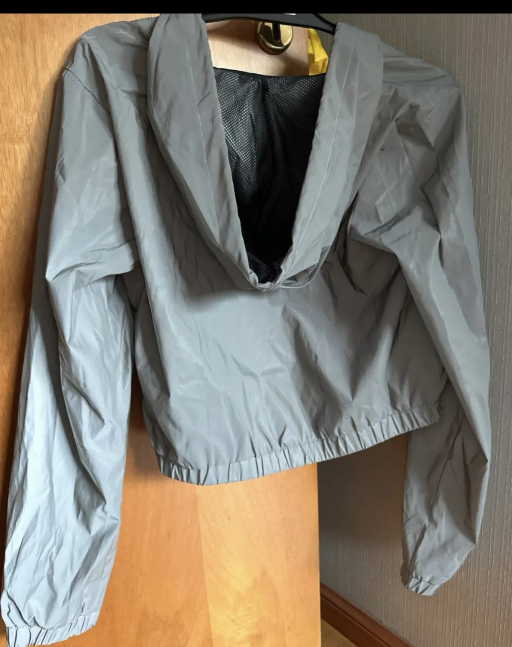 Campera rompevientos gris de mujer, con capucha y cierre. Ideal para actividades deportivas o uso casual. Marca Forever 21.