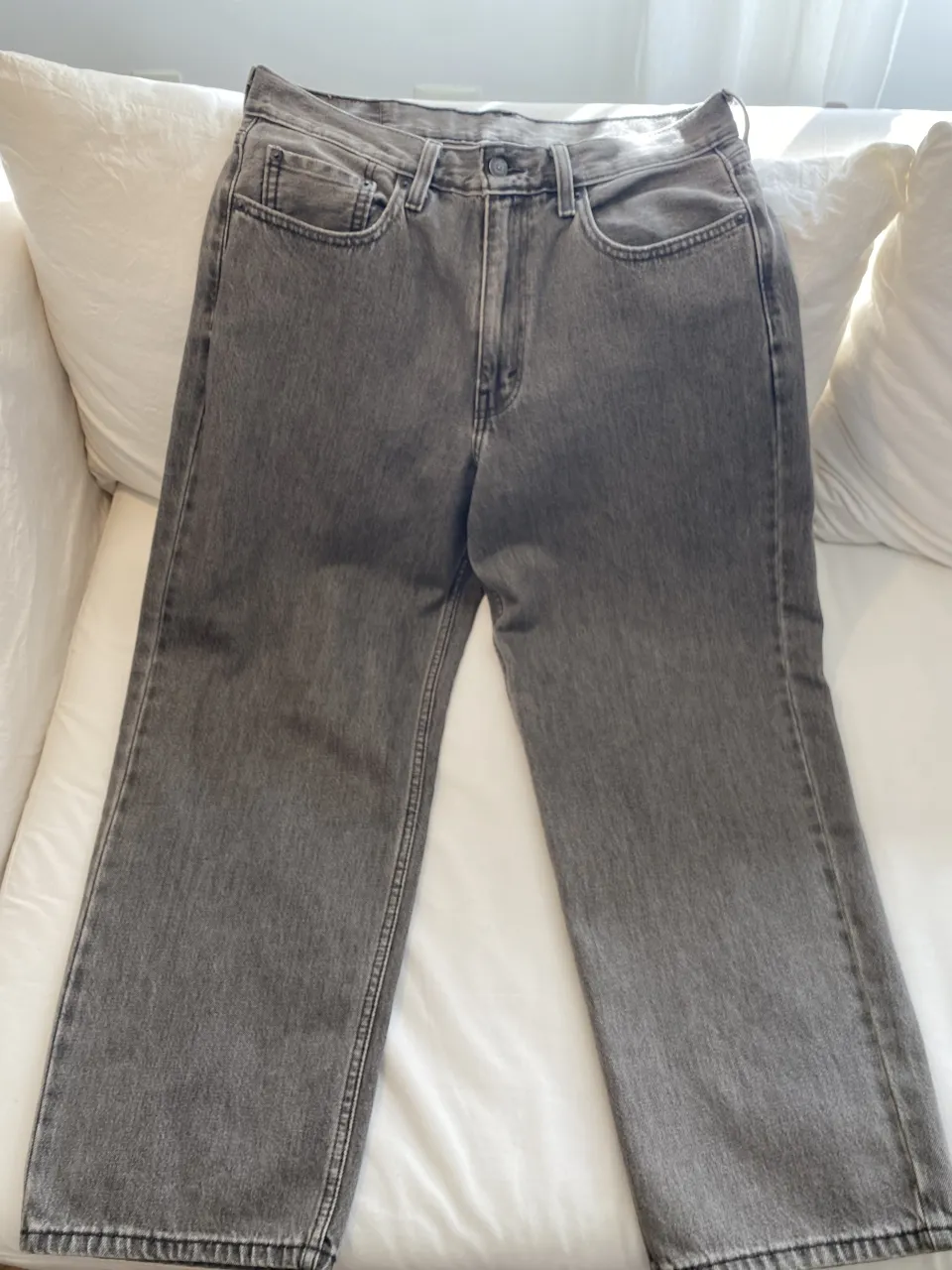 Jeans grises de corte recto. Cuentan con cinco bolsillos y cierre.