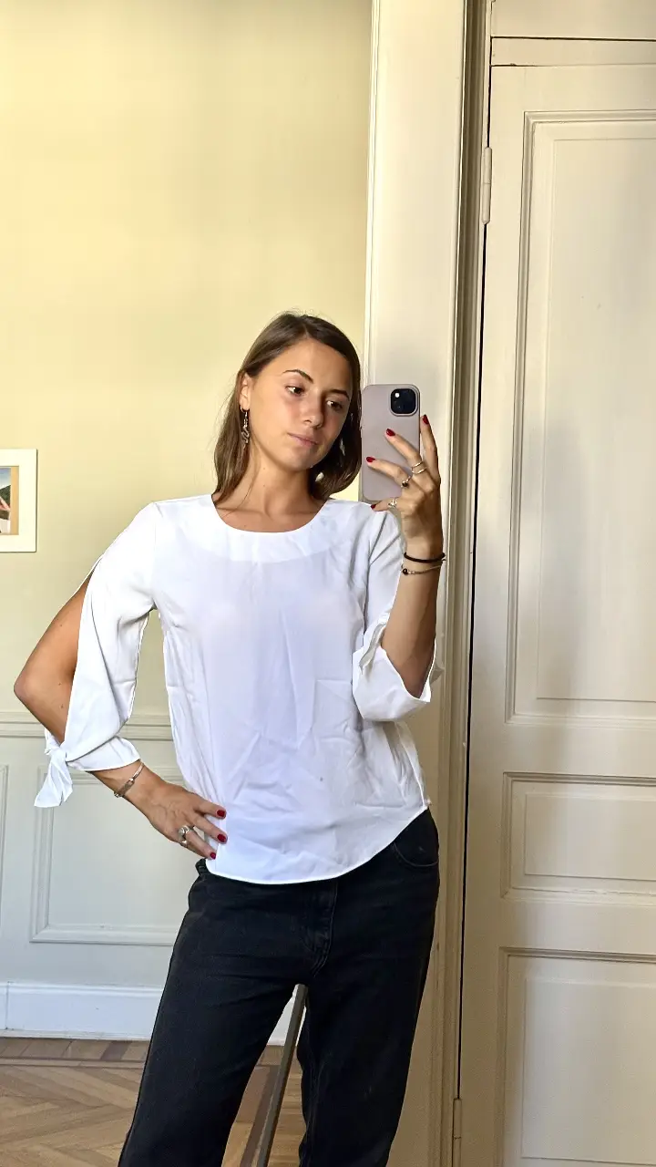 Blusa blanca de mujer, con mangas 3/4 con detalle de lazo. Ideal para un look casual y elegante.
