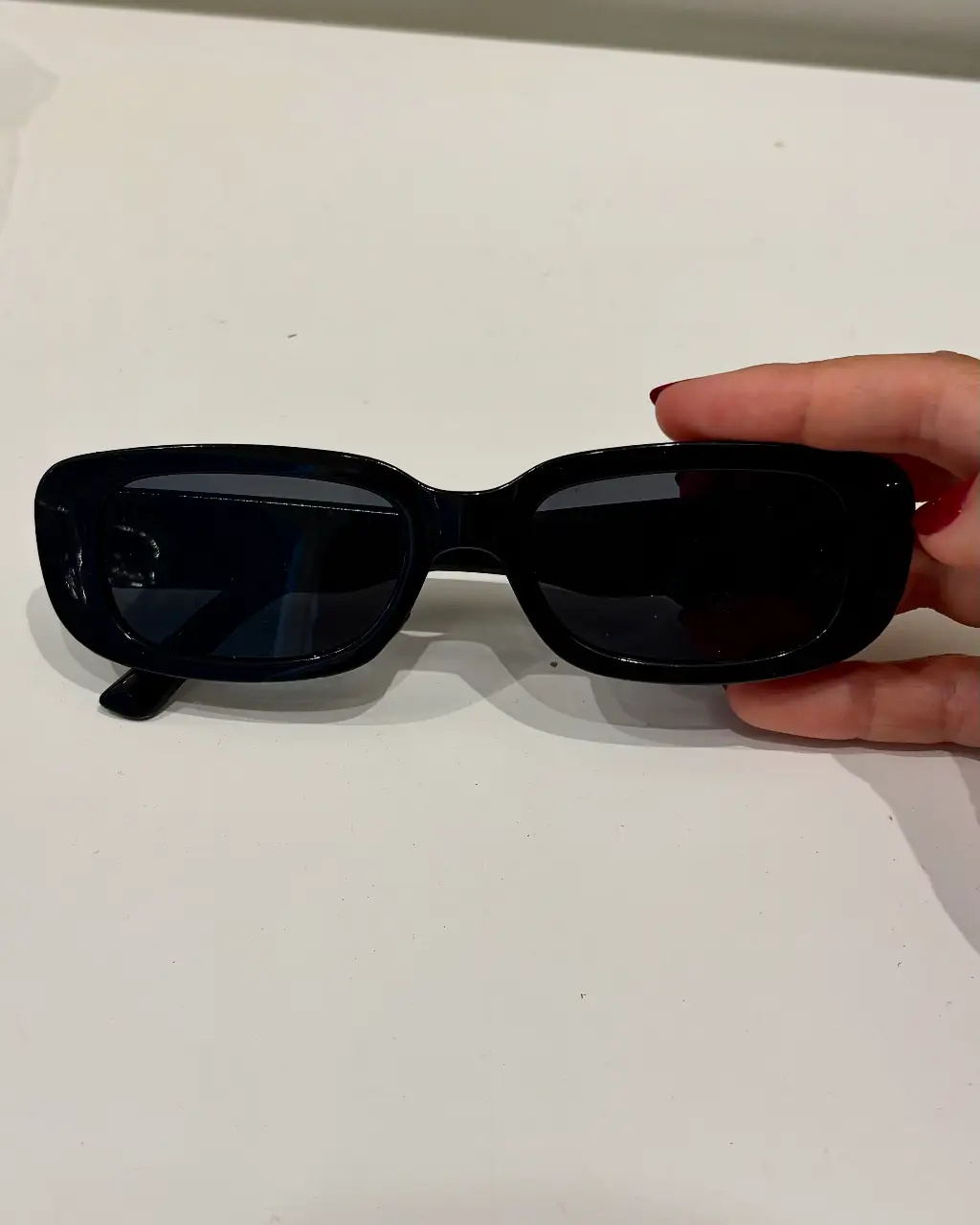 Anteojos de sol negros, estilo rectangular, ideales para un look moderno y versátil. Perfectos para proteger tus ojos con estilo.