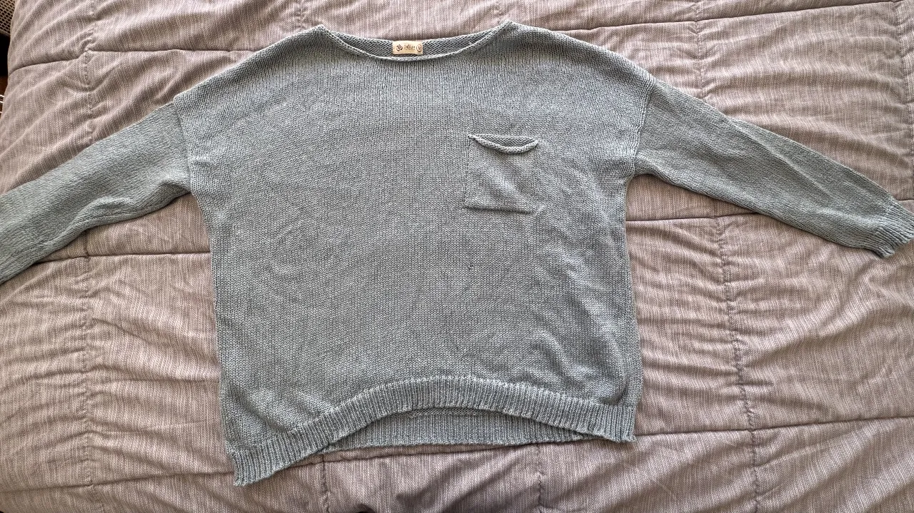 Sweater de punto celeste/verdoso, con bolsillo en el pecho. Talle M. Ideal para un look casual y cómodo. 