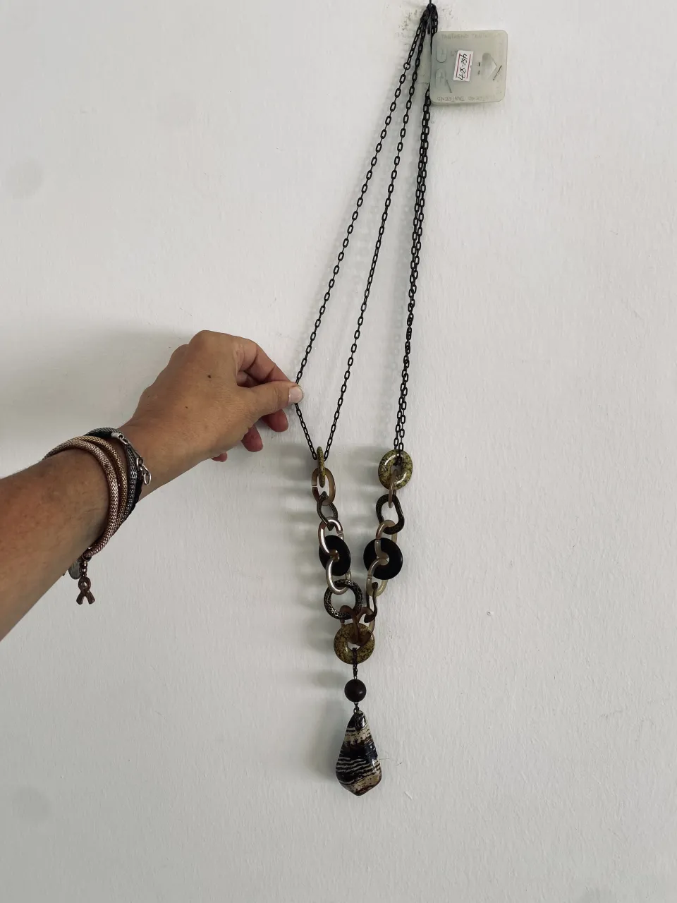 Collar largo con eslabones y dije de piedra veteada.