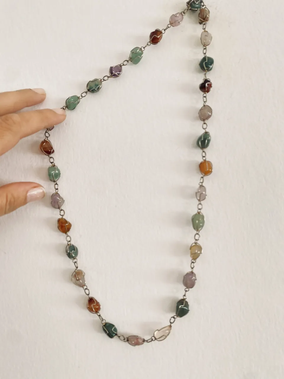 Collar largo con piedras naturales irregulares de diversos colores engarzadas en metal.