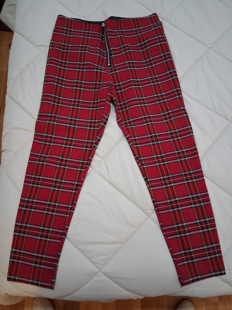 Pantalón de vestir para mujer, de corte recto y tiro alto, con estampado a cuadros escoceses en rojo y negro. Cuenta con cierre frontal y cintura elastizada. Ideal para un look moderno y audaz.