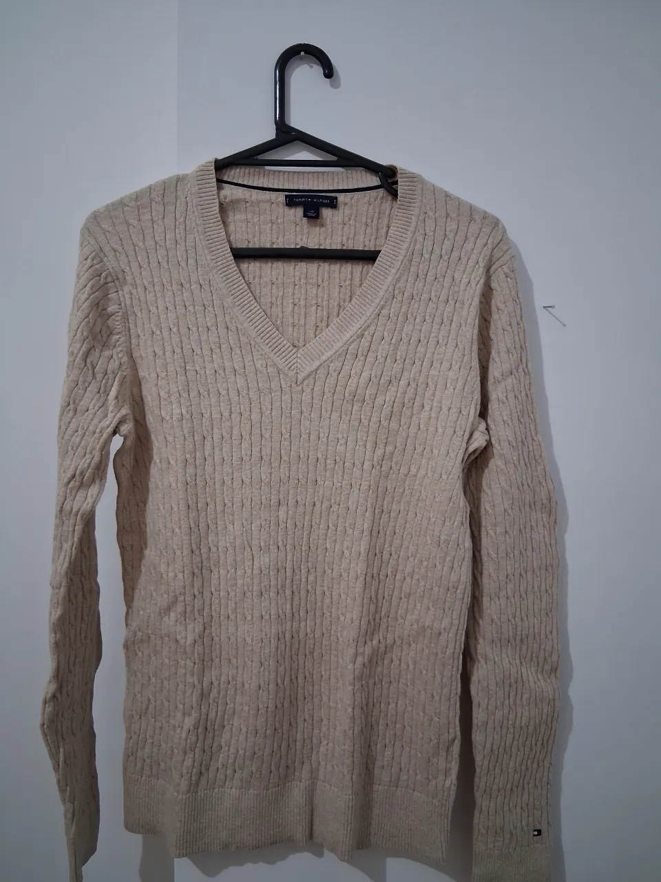 Sweater Tommy Hilfiger color crudo, con cuello en V y diseño tejido. Ideal para un look casual y abrigado.