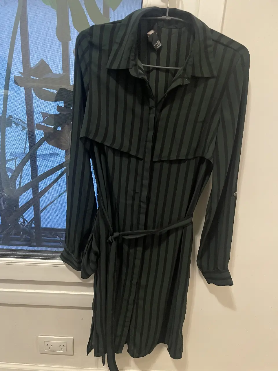 Vestido midi de Forever 21, a rayas verticales en verde oscuro y negro. Con mangas largas (ajustables), cinturón para ajustar la cintura y detalle de solapa en la parte superior. Ideal para un look elegante y versátil.