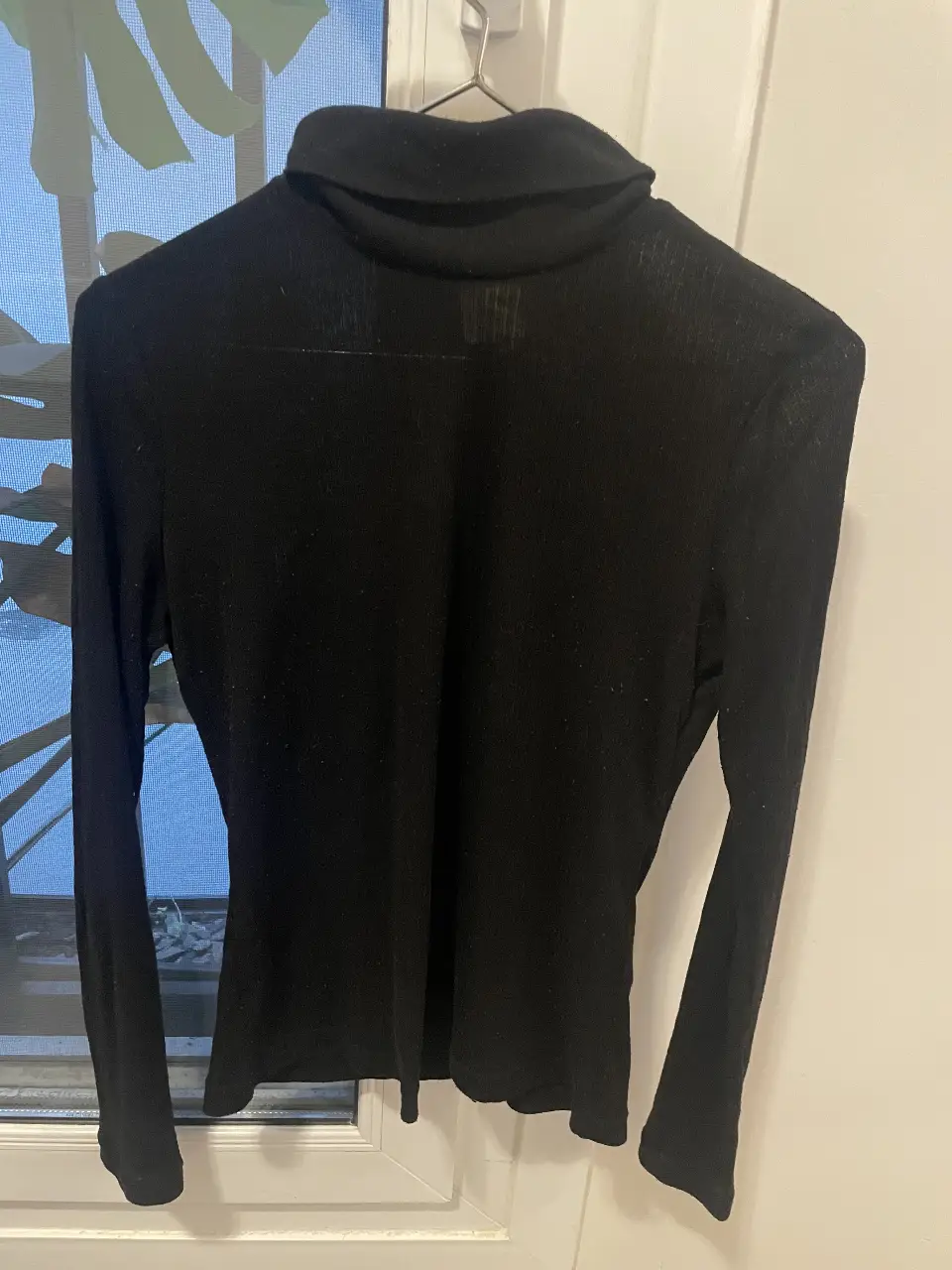 Remera de cuello alto, manga larga, de tejido fino y elastizado. Ideal para un look elegante y versátil.