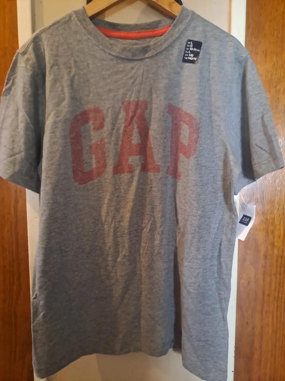 Remera de hombre de algodón gris con estampado "GAP" en rojo. Talle L, ideal para un look casual y cómodo.