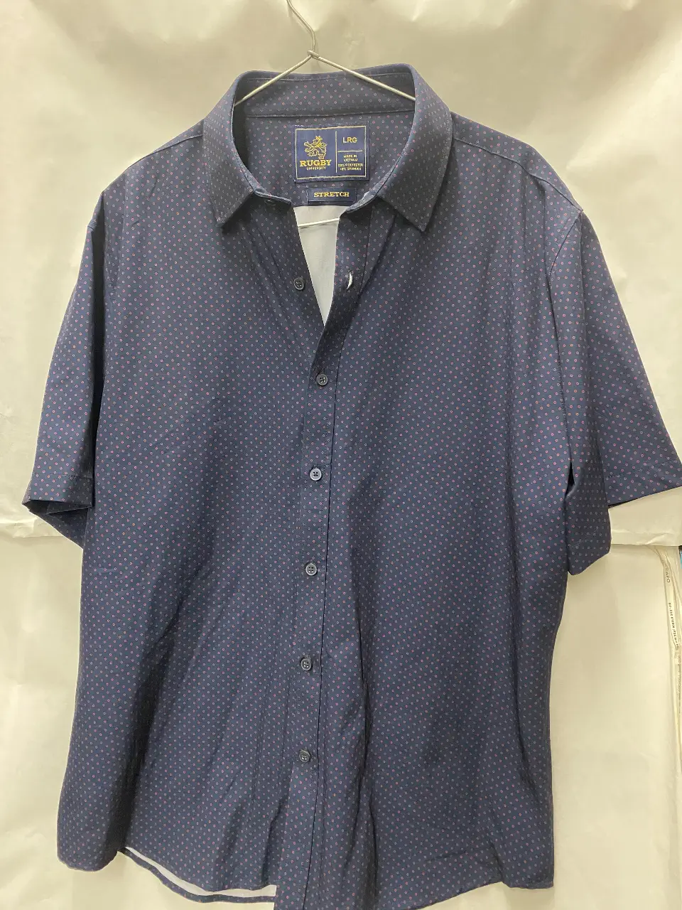 Camisa de hombre Rugby University, manga corta, con estampado de lunares. Talle L. Confeccionada en 90% poliéster y 10% spandex. Ideal para un look casual y moderno.