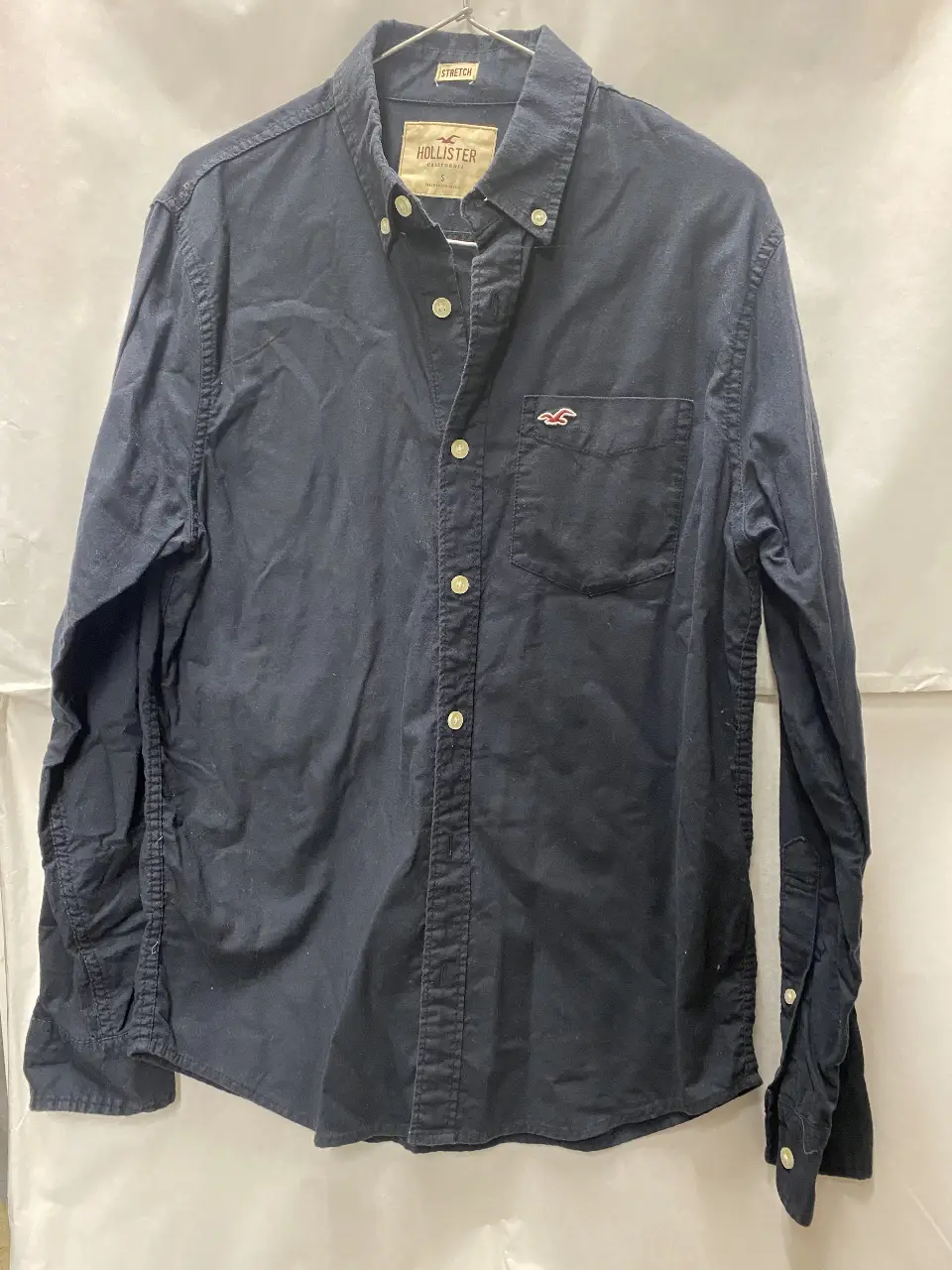 Camisa de hombre Hollister, color azul oscuro, talle S. Con bolsillo en el pecho y logo bordado. Ideal para un look casual y cómodo.