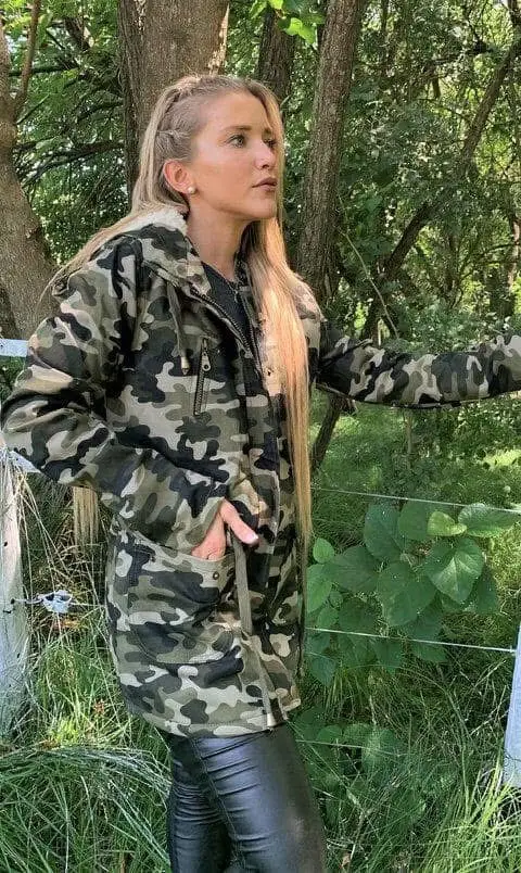 Campera de mujer estilo militar con estampado camuflado. Posee capucha con borde de piel sintética, cierre y bolsillos. Ideal para un look casual y abrigado.
