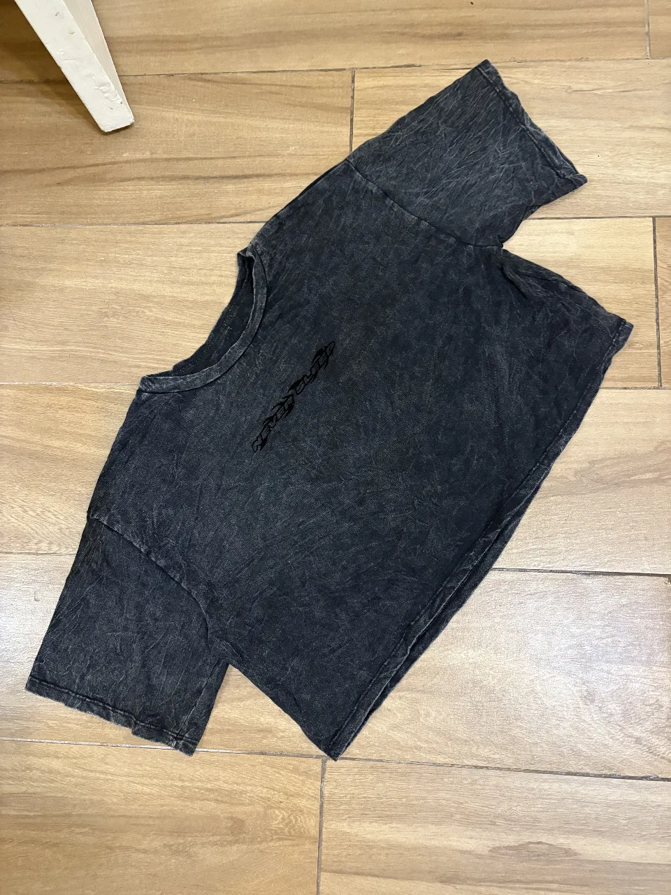 Remera negra con efecto desgastado, corte crop y cuello redondo. Ideal para un look urbano y canchero.