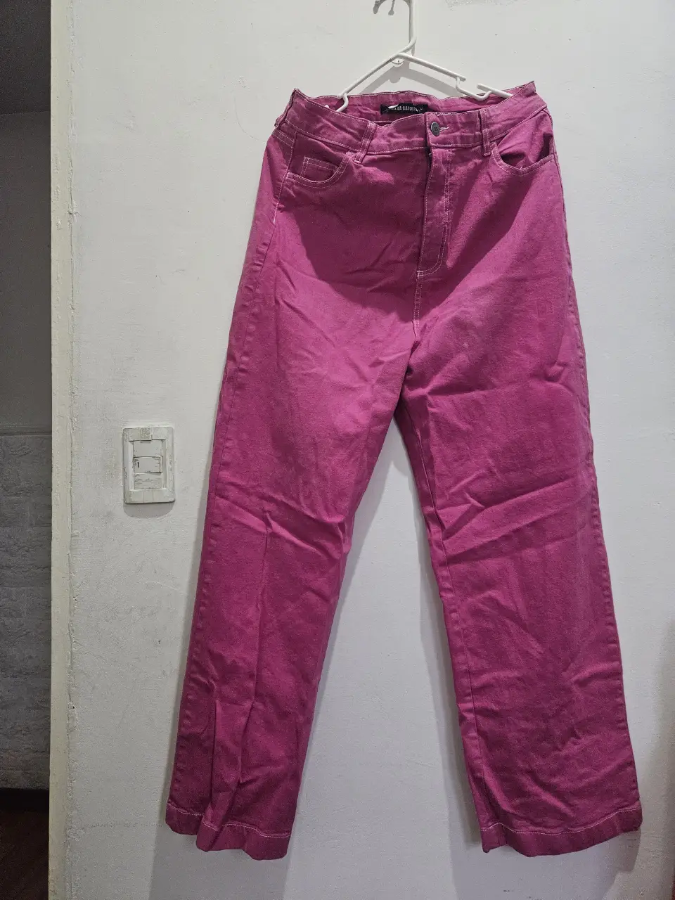 Pantalón suelto de jean en color rosa vibrante. Ideal para un look casual y moderno. Perfecto para combinar con remeras y zapatillas. tiene una mancha, pero está en buenas condiciones.