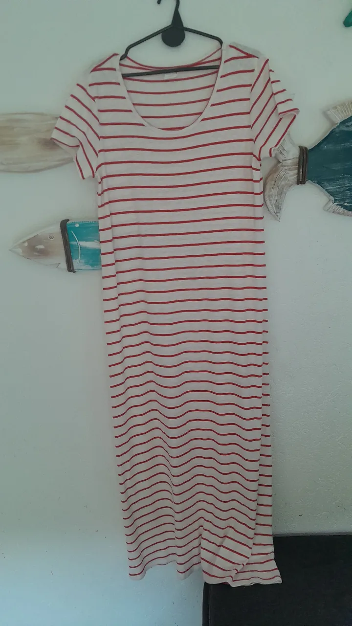 Vestido largo de algodón blanco con rayas rojas horizontales. Tiene mangas cortas y cuello redondo.