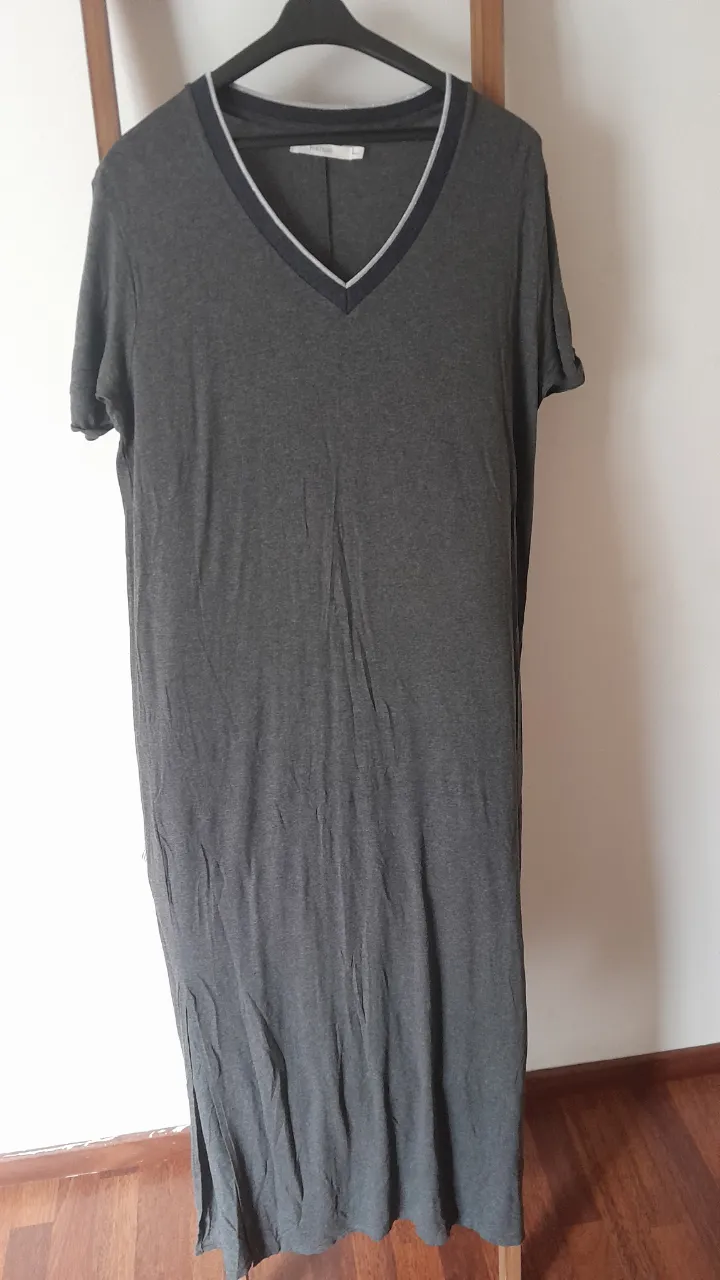 Vestido largo gris de mangas cortas, con cuello en V y detalles de ribb en el cuello. Posee tajos laterales para mayor comodidad. Ideal para un look casual y relajado.